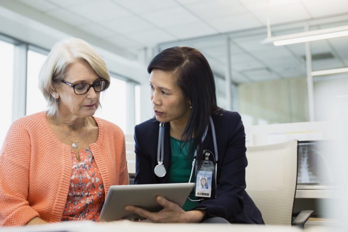 Doctor and patient using digital tablet in clinic